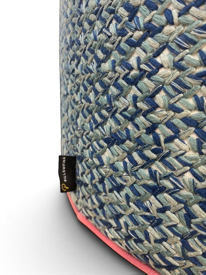 Pillowfina slate blue leather ottoman stool with peacock woven lacing and watermelon velvet welt trim.