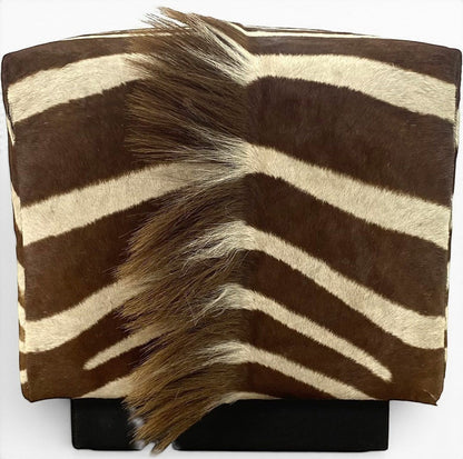 Pillowfina vintage zebra hide cube ottoman with natural brown and cream stripes and textured mane detail.