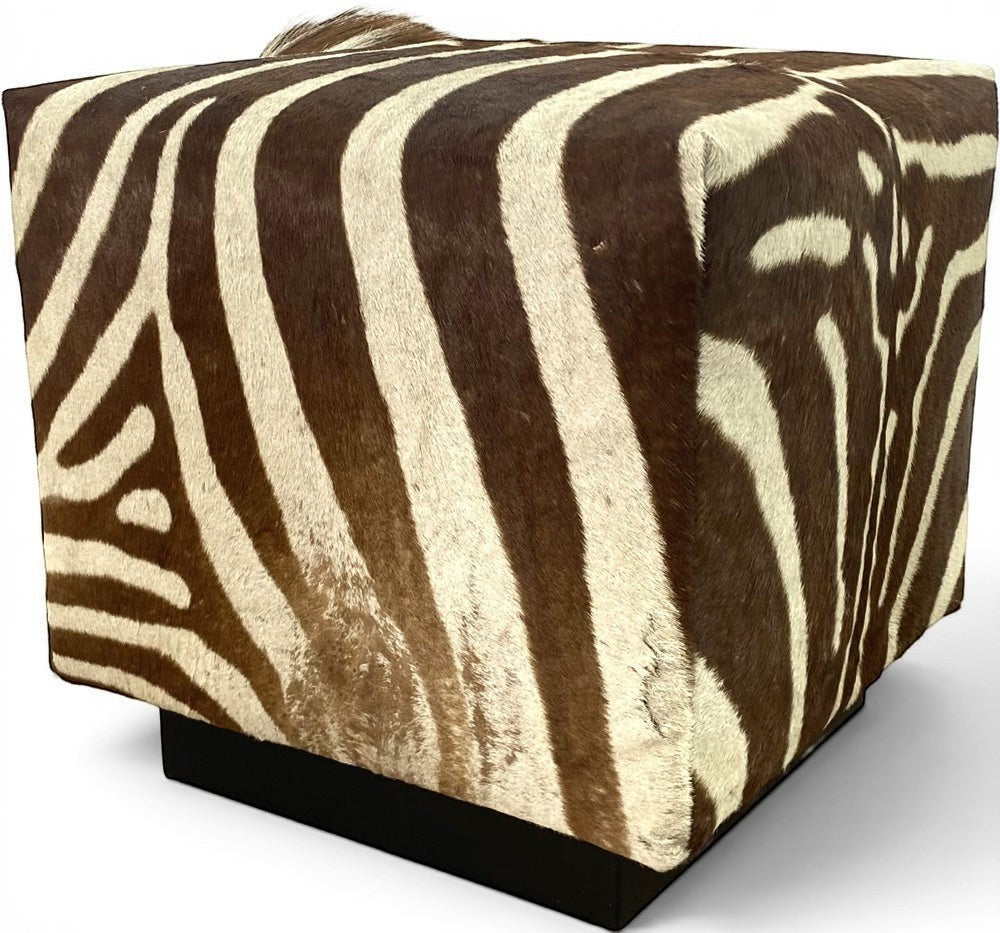 Pillowfina vintage zebra hide cube ottoman with natural brown and cream striped fur pattern on a black base.