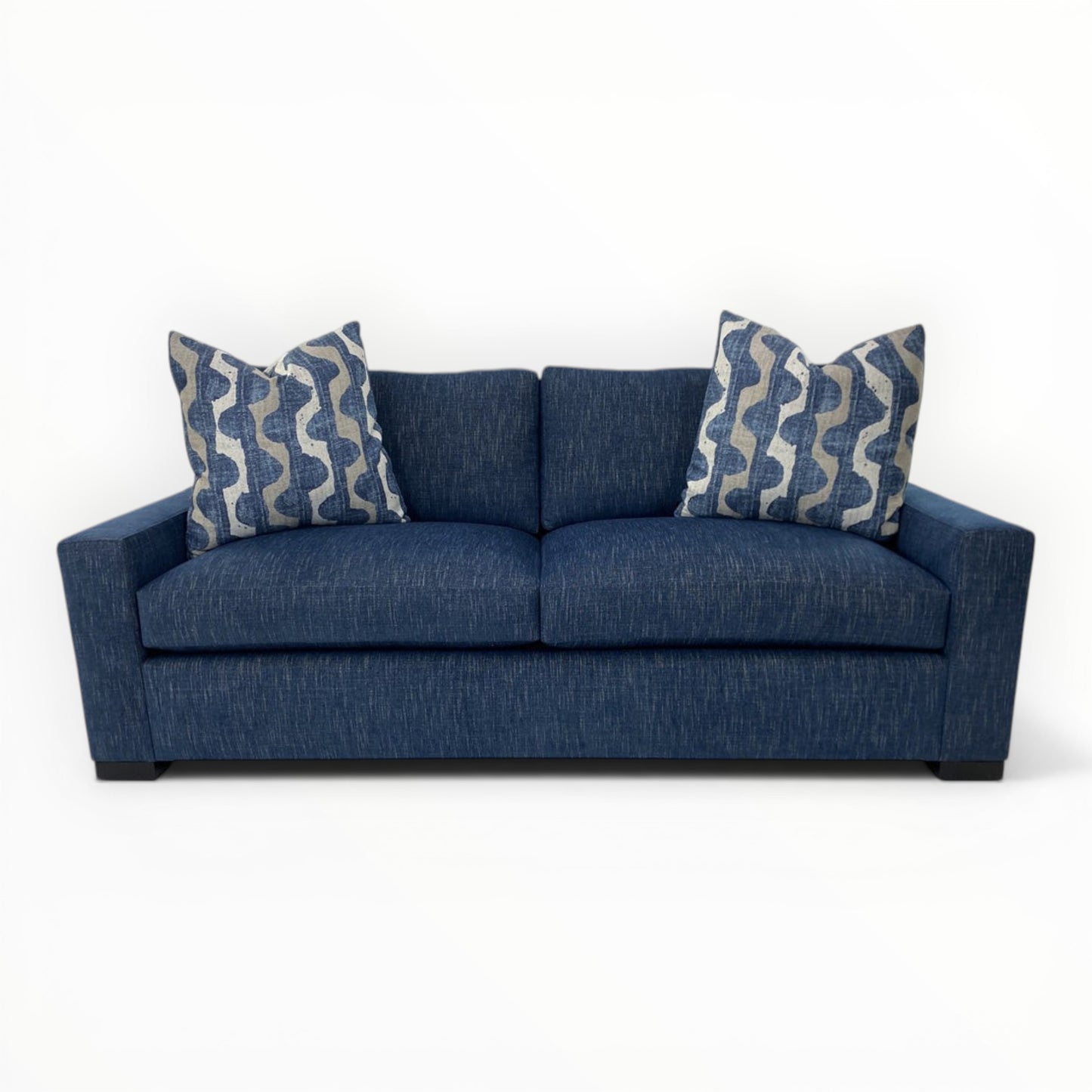 Robert Allen Lagan Azure throw pillows shown on a modern navy sofa