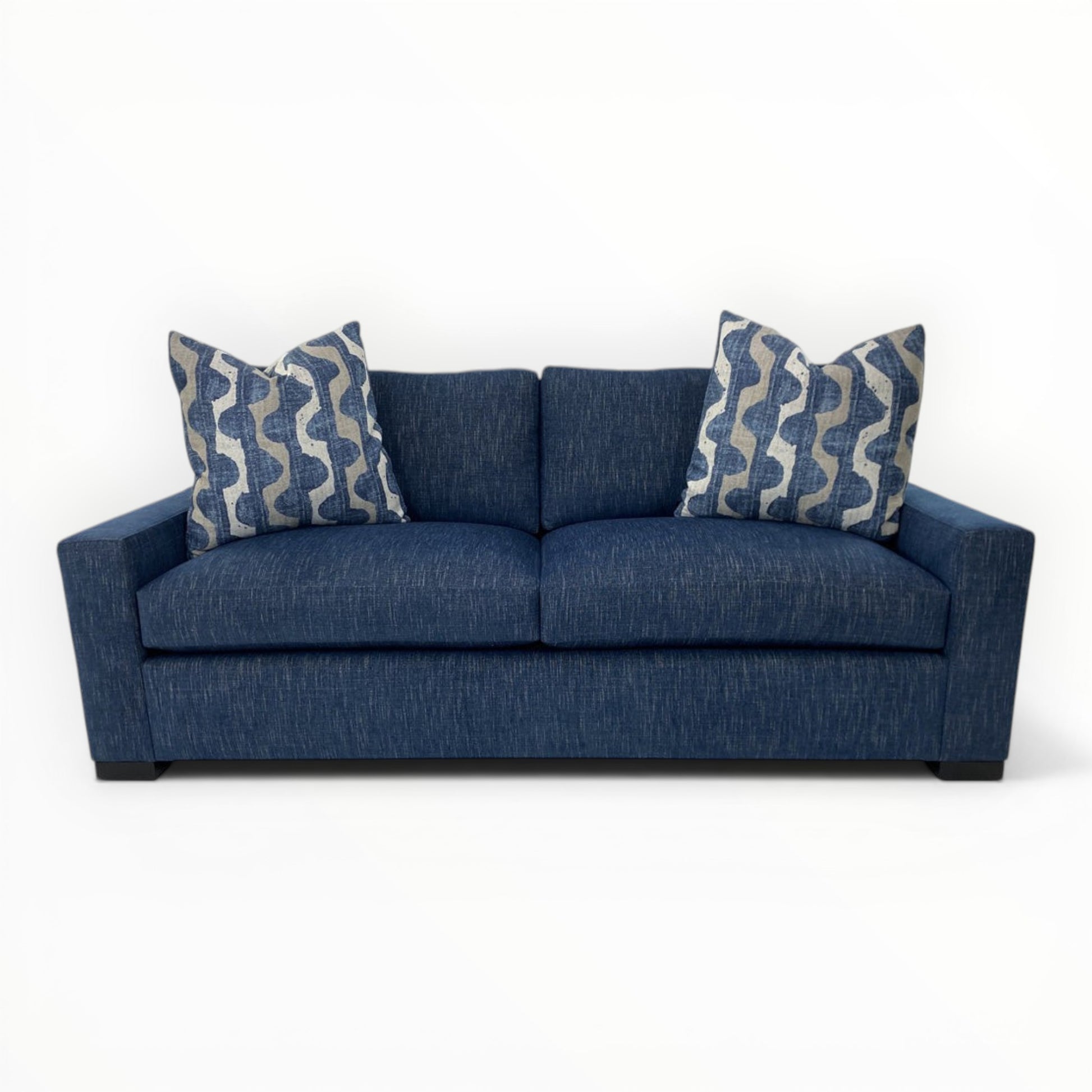 Robert Allen Lagan Azure throw pillows shown on a modern navy sofa