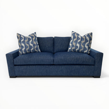 Robert Allen Lagan Azure throw pillows shown on a modern navy sofa